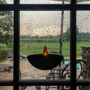 Enlite10 candle adhered on window on rainy day